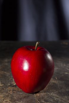 Red ripe apple on an old wooden table