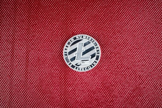 Digital currency physical silver litecoin coin on the red background