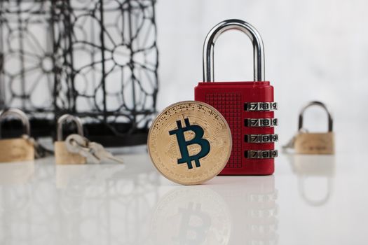 Digital currency physical gold bitcoin coin near red numeric padlock.