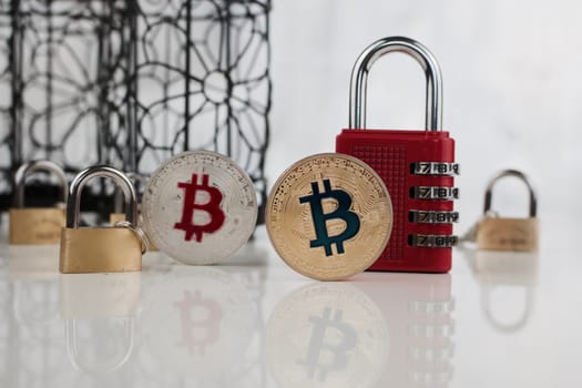 Digital currency physical gold and silver bitcoins near padlocks.