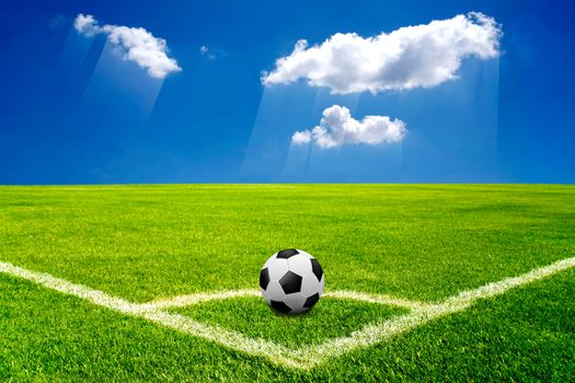 soccer ball on corner green field with blue sky and cloud