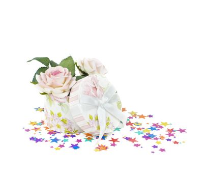 Gift box with rose flowers on a background of confetti in the form of stars,  isolated on white
