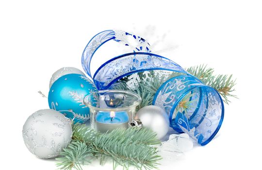 Beautiful Christmas card with burning candle, blue and silver Christmas balls, blue ribbon and fir branches, isolated on a white background