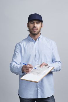 Handsome young delivery man holding document folder ask to sign invoice