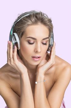 Beautiful woman with natural makeup listening music in headphones