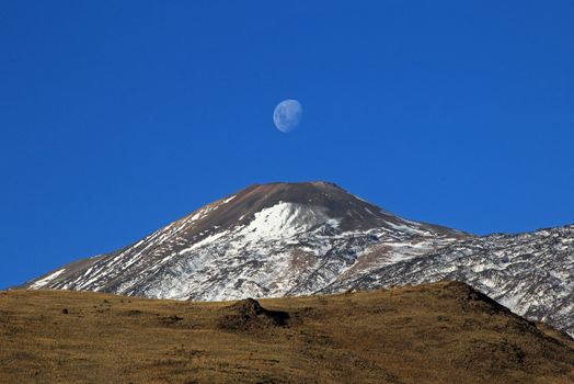 Snowcovered Volcano Tromen with full moon, Patagonia, Argentina