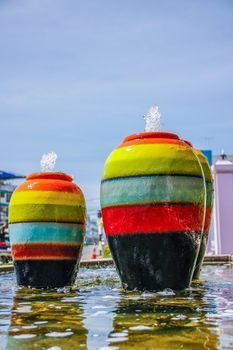 colorful jar pot fountain in pond front of entrance door