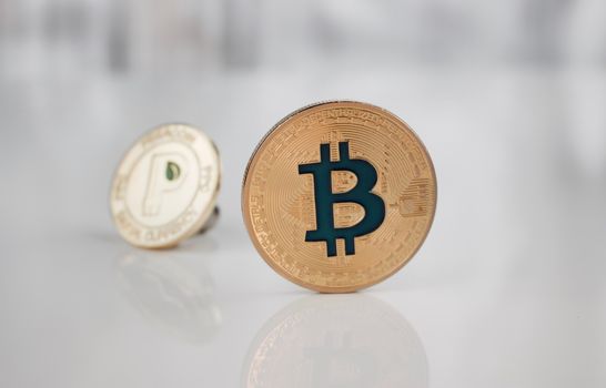 Cryptocurrency physical gold bitcoin coin and gold peercoin coin.