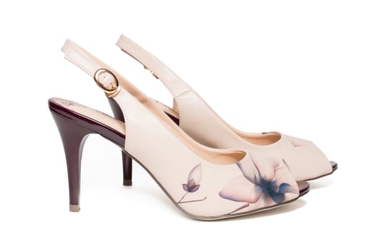 The photo shows female beige shoes on a white background