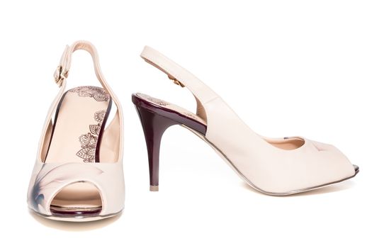 The photo shows female beige shoes on a white background