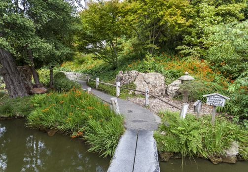 Japanese Garden pathway leading to zen. The garden features a pond which holds a beautiful collection of koi fish.