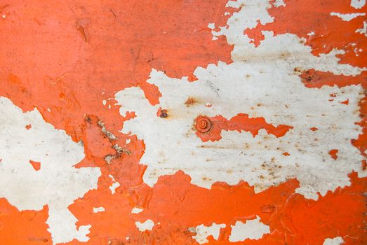 fragment of an iron surface is covered with orange and grey color paint, which has long been under the influence of different climatic conditions