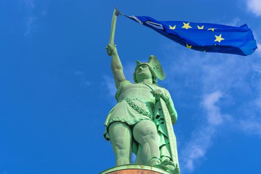 Statue of the Cherusque prince Arminius in Teutoburg Forest in Germany.
On the sword of the statue a European flag flapping in the wind.