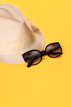 Summer woman's hat and glasses on a yellow background