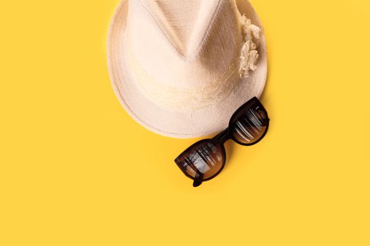 Summer woman's hat and glasses on a yellow background