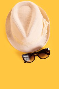 Summer woman's hat and glasses on a yellow background