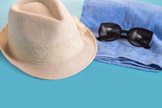 Summer woman's hat and glasses on a blue background