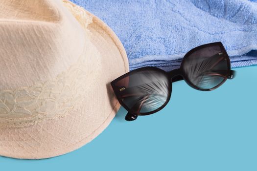 Summer woman's hat and glasses on a blue background