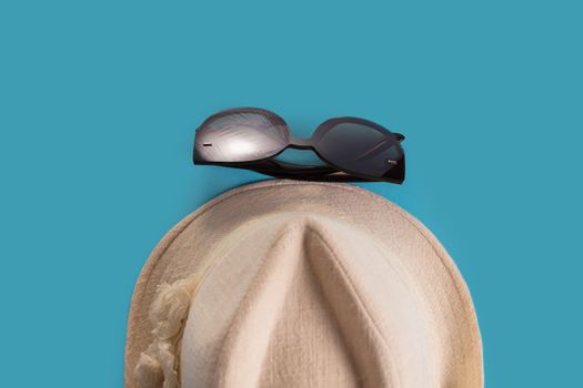 Summer woman's hat and glasses on a blue background