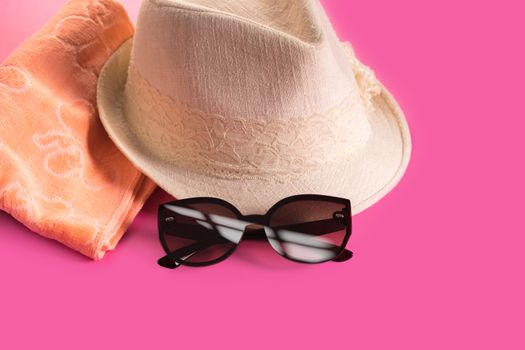 Summer woman's hat and glasses on a pink background