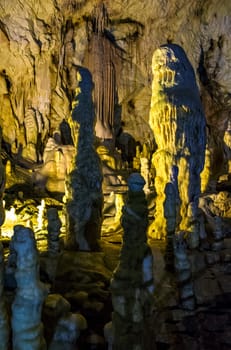cave with colourful textured walls and stalactites and stalagmite