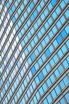 Blue glass windows of modern business office building, diagonal perspective, low angle view