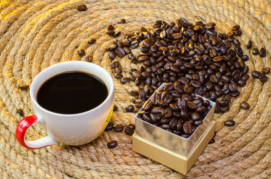 Cup of coffee with box gold Square on a jute rope.