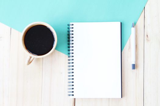 Still life, business, office supplies or education concept : Top view image of open notebook with blank pages and coffee cup on wooden background, ready for adding or mock up