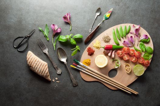 Colorful herbs spices and fresh ingredients on a painters palette