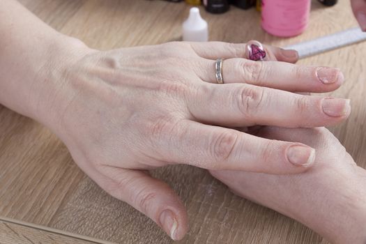 Professional manicure procedure in beauty salon. Hands close up.