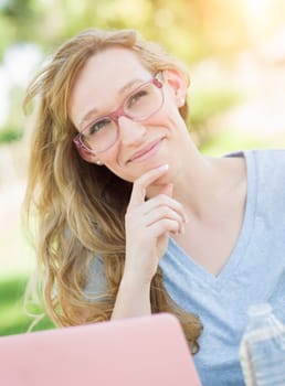 Young Adult Woman Wearing Glasses Outdoors Using Her Laptop.