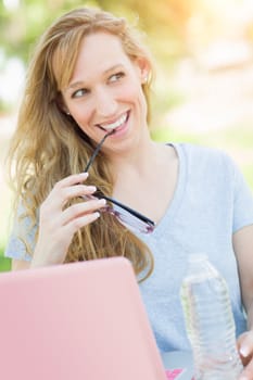 Young Adult Woman With Glasses Outdoors Using Her Laptop.