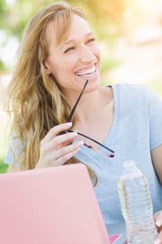 Young Adult Woman With Glasses Outdoors Using Her Laptop.