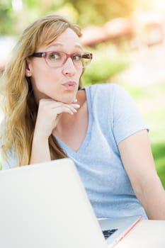 Young Adult Woman Wearing Glasses Outdoors Using Her Laptop.