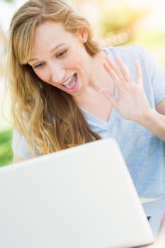 Young Adult Woman Live Video Chatting Outdoors Using Her Laptop.