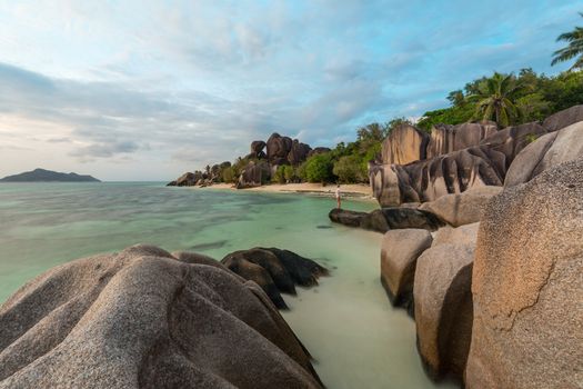Beautifully shaped granite boulders and a dramatic sunset at picture perfect tropical Anse Source d'Argent beach, La Digue island, Seychelles.