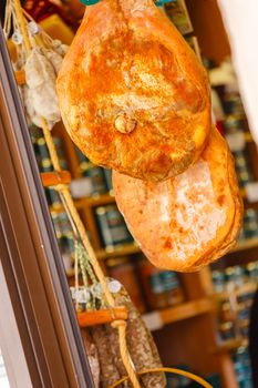 Jamon serrano hung at the entrance of a gourmet shop