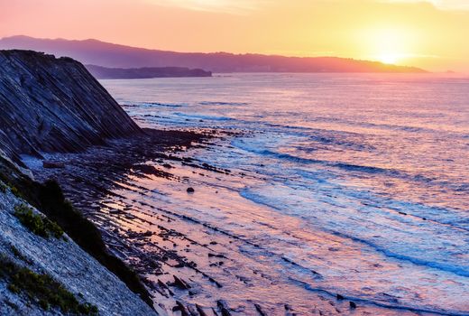 Sea Cliff on sunrise with beautiful dramatic sky and ocean shore on the background