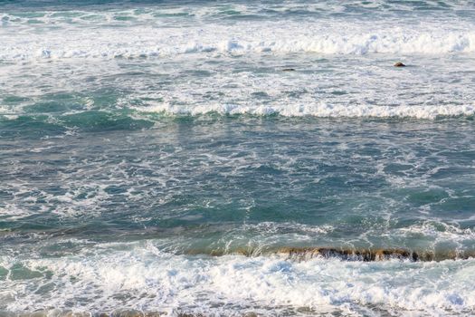 Seascape with rocks, foam and spray of the waves