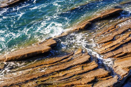 Seascape with rocks, foam and spray of the waves