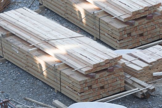 Stack of wooden beams and planks. Building materials for a construction site.