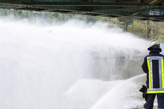 Fire department sprayed extinguishing water from fire hoses during an exercise.
