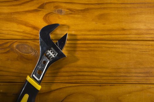 New adjustable wrench on a wooden background