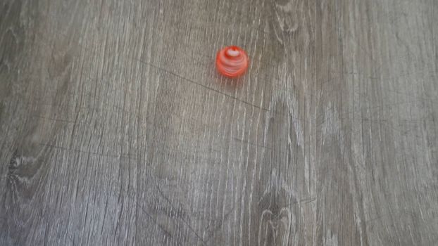 a red cube spinning on grey laminate Slow motion.