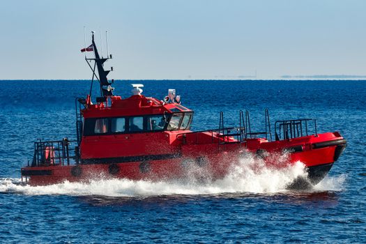 Red pilot ship moving from the Baltic sea