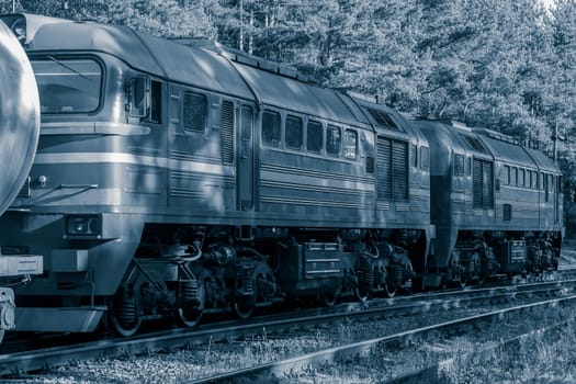 Diesel cargo locomotive with oil tanks in forest