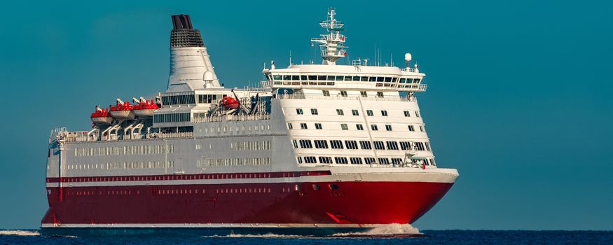 Red cruise liner. Large passenger ferry underway