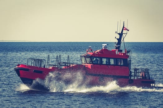 Red pilot ship moving from the Baltic sea