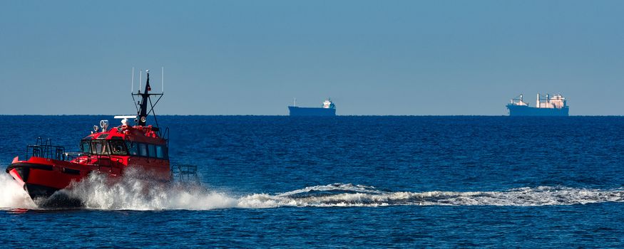 Red pilot ship moving from the Baltic sea