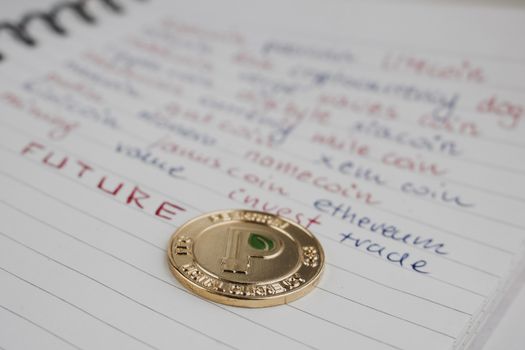 Digital currency physical gold peercoin coin in notebook.